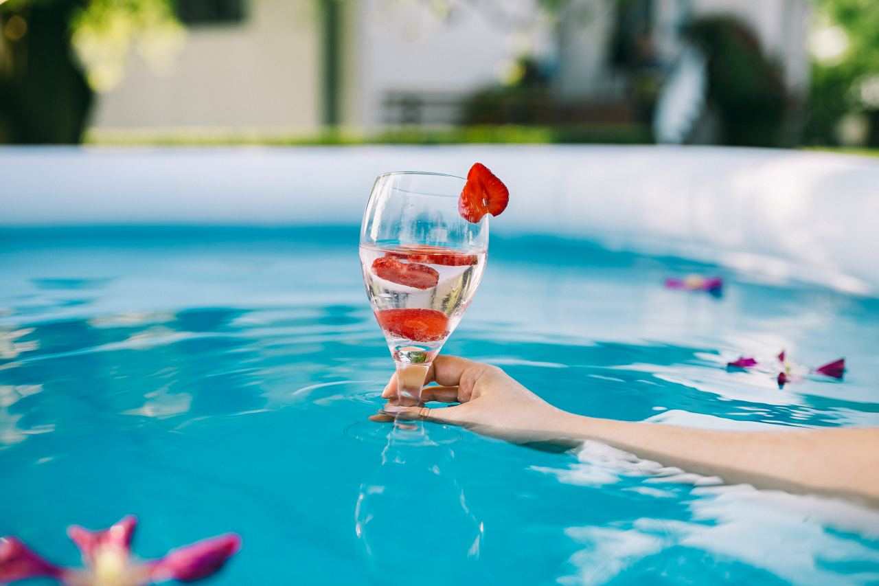 kaboompics.com_Strawberry cocktail in the female hand at the poolside